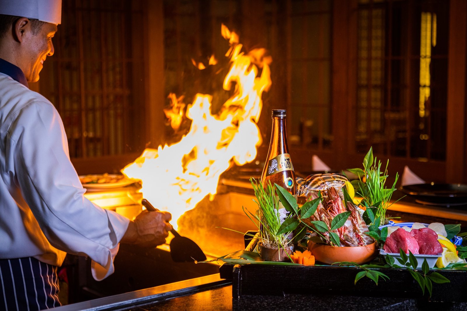  Family enjoying dinner at RACV Royal Pines Arakawa's teppanyaki table while watching chef flambé hot plate. Arakawa 2025