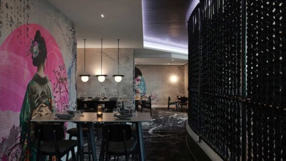 Family enjoying dinner at RACV Royal Pines Arakawa's teppanyaki table while watching chef flambé hot plate. Arakawa